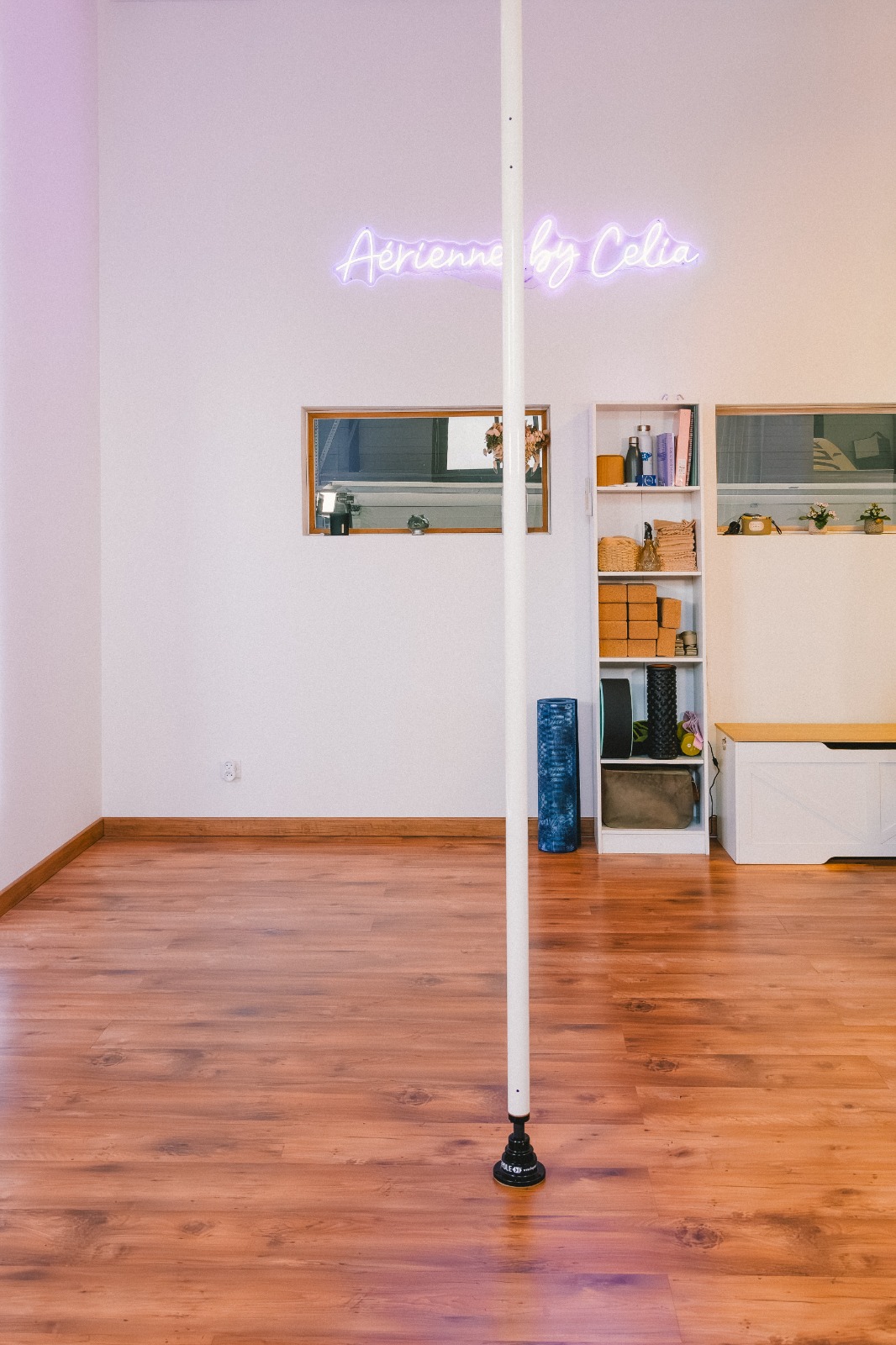 Studio Aériennes by Célia à Gignac, néon mauve, barre de pole dance et parquet chaleureux